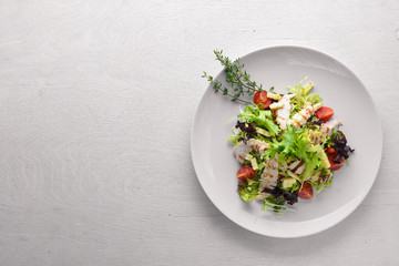 Fresh vegetables and grilled chicken salad. On a wooden background. Top review. Free space.