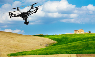 A flying drone with camera with blured hills of Tuscany in the background