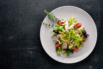 Fresh vegetables and grilled chicken salad. On a wooden background. Top review. Free space.