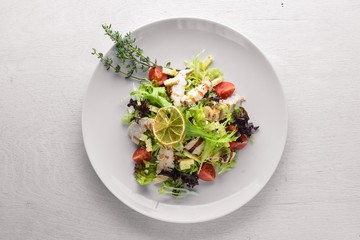 Fresh vegetables and grilled chicken salad. On a wooden background. Top review. Free space.
