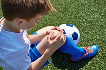 Fotobehang Injury of knee in boy football © Sergey Ryzhov