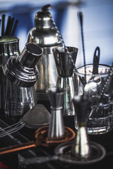 Classic bar cocktail shaker, bartender tools, a set of equipmen in blurred background