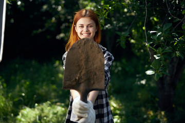 Beautiful young woman running in the garden, gardener