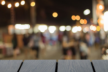 Mock up black wooden table font and blurred walking street background