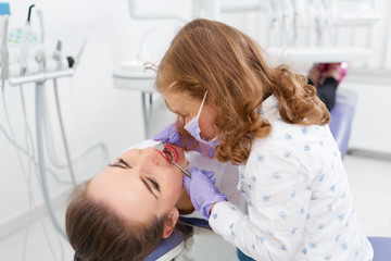 Little girl examining dentist in cabinet