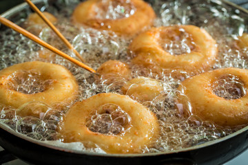 Frying sweet and tasty donuts on fresh oil