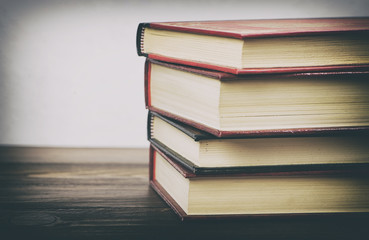 Books stacked on wooden table.
