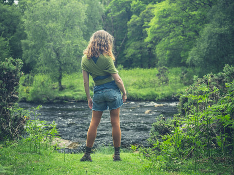 Young woman standing by river in nature