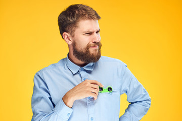 A young guy with a beard on a yellow background holds a spinner