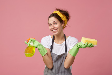 Beautiful good-looking young housewife doing household chores on weekend: dusting, washing floor...