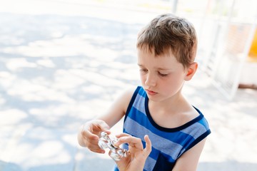 Little child boy playing with fidget spinner