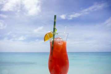 Summer cocktail against tropical sea and sky background