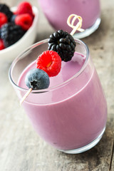 Healthy berry smoothie in glass on wooden table
