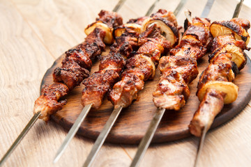 Grilled pork on skewers roasted on the grill on wooden chopping board
