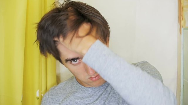 A Young Man Combs His Damp Hair Back With A Black Comb.