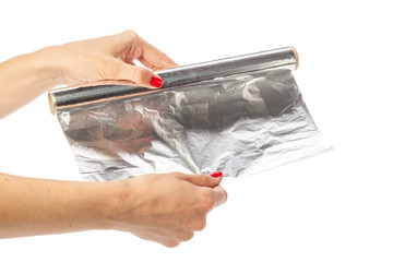 human hand holding a roll of foil on a white background