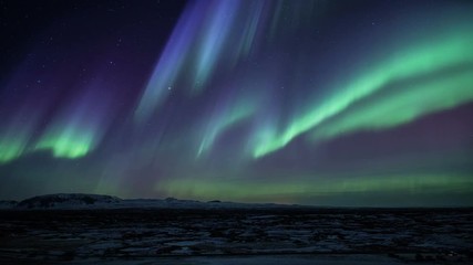Strong bright Aurora Borealis snow covered lava field mountains Thingvellir Iceland realistic movement 4k - Powered by Adobe