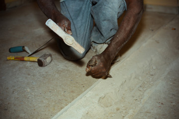 Closeup on construction worker doing renovation work holding tools on building background