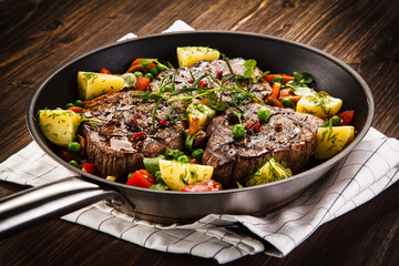 Grilled steak, baked potatoes and vegetables 