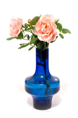pink roses with water drops in blue vase isolated on white background
