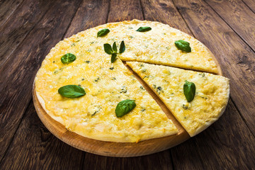 Delicious four cheese pizza with basil leaves