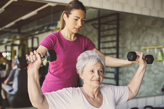 Senior woman workout in rehabilitation center. Personal trainer helping senior woman.