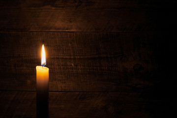 Fototapeta na wymiar candle on old wooden background