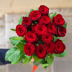 hand holding bouquet of roses