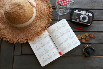 Planning cheap travel budget. Opened book with calendar