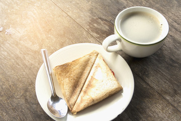 Coffee and baking bread on a wood table with a new morning.