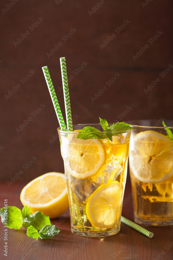 Wall mural ice tea with lemon and mint on dark rustic background