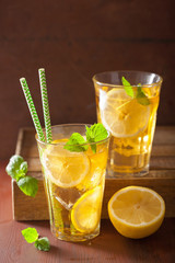 ice tea with lemon and mint on dark rustic background