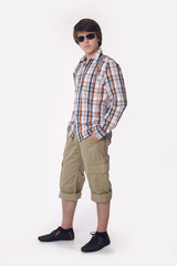 Fototapeta premium Handsome in style. Young man in smart casual wear looking at camera and holding hands in pockets while standing isolated on studio white background