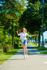 Young blond hair woman, student have fun and feeling freedom in city park