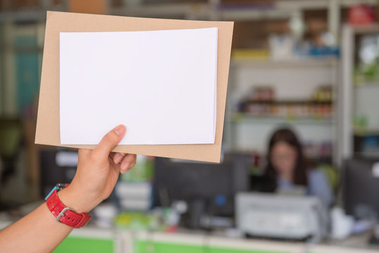Blank white paper in the woman's hand in office.