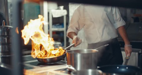 backstage workflow in the restaurant's kitchen, roasting vegetables in a wok with fire, close-up