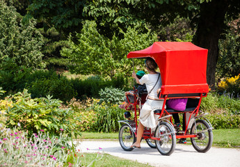 Fototapeta na wymiar Family cycling in park in summer. Parc floral (public park and botanical garden) in Paris, France.