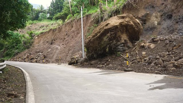 Landslides and rockfalls on the road in the mountains. Mud and rocks blocking the road.Destroyed rural road landslide damaged in powerful flood. Collapsed on the mountain. Philippines, Camiguin. 4K