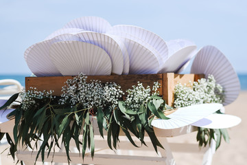 Fans decorated with flowers for a wedding beach ceremony
