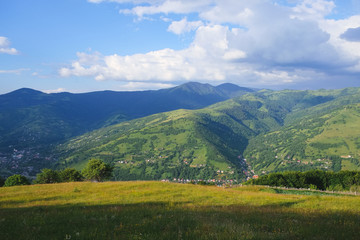 Carpathian village at meadows in sunshine light