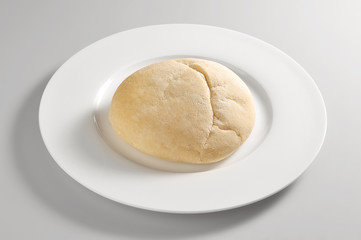 Round dish with a single Arabic bread