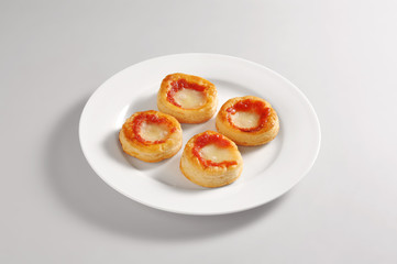 Round dish with four small pizzas