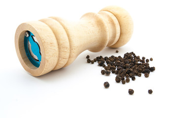 pepper mill of wood with peppercorns
