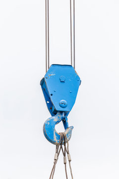 The old blue lifting crane hook is used in construction site on white background.