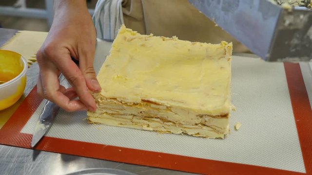 Cook taking out layer cake from cake form