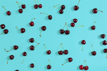 Fresh juicy cherries on mint background, top view