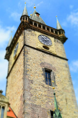 The clock tower of Old Town Hall in Prague in Czech Republic, with blue sky and white clouds in the background. Tilt-shift effect applied.