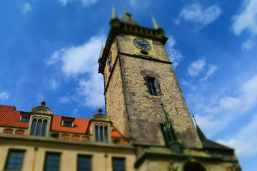 Fototapeta na wymiar The clock tower of Old Town Hall in Prague in Czech Republic, with blue sky and white clouds in the background. Tilt-shift effect applied.