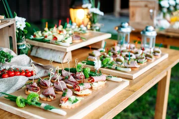 Papier Peint photo Buffet, Bar Belle table de buffet de banquet de restauration décorée dans un style rustique dans le jardin. Différentes collations, sandwichs. Extérieur.