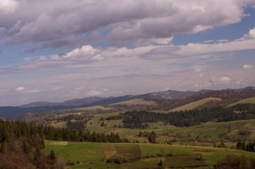 Fototapeta premium Beautiful mountain landscape, with mountain peaks covered with forest and a cloudy sky. Carpathian mountains, Europe